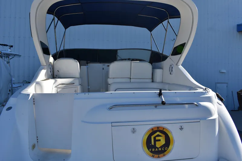 Slide: The Image of 2003 Bayliner 305 boat with white seating and blue canopy. - 18