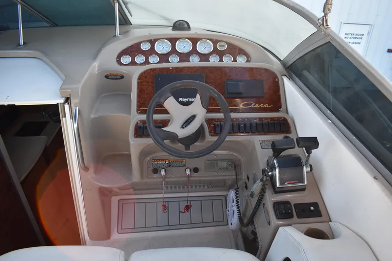Slide: The Image of 2003 Bayliner 305 boat cockpit with steering wheel and control panel. - 21