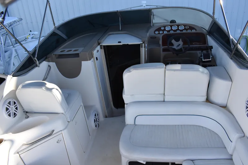 Slide: The Image of 2003 Bayliner 305 boat interior with white seating and helm station. - 24