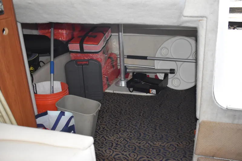 Slide: The Image of Storage area inside a 2003 Bayliner 305 boat with various equipment and supplies. - 27