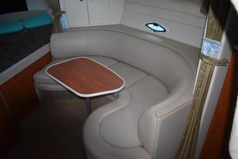 Slide: The Image of 2003 Bayliner 305 interior with curved seating and wooden table. - 29