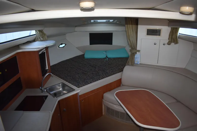 Slide: The Image of 2003 Bayliner 305 interior with kitchenette, dining area, and sleeping quarters. - 30