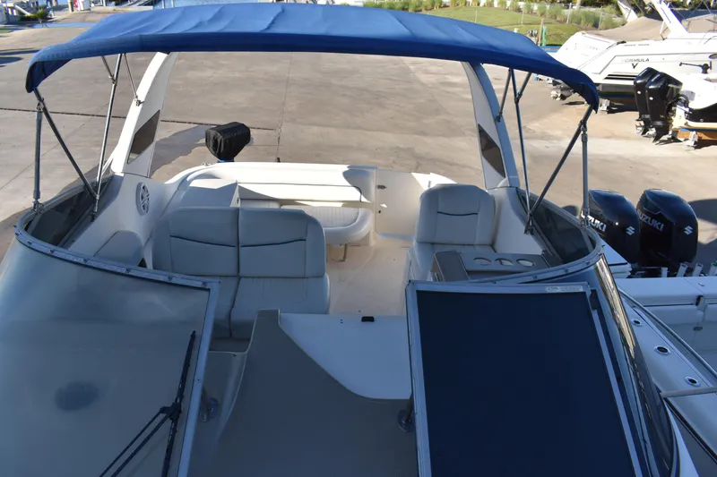Slide: The Image of 2003 Bayliner 305 boat with blue canopy and white seating. - 34