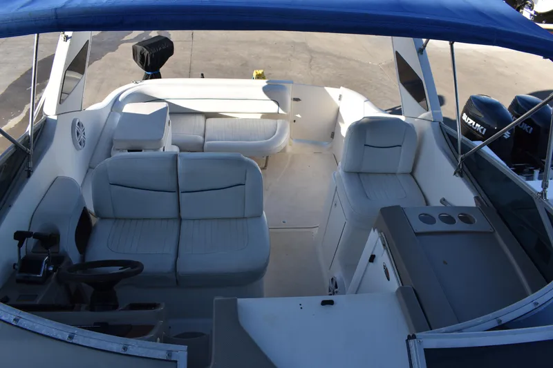 Slide: The Image of 2003 Bayliner 305 boat interior with white seating and blue canopy. - 35
