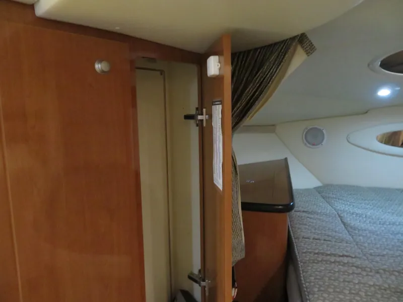 Slide: The Image of 2005 Maxum 3300 SE cabin interior with wood paneling and bed. - 11