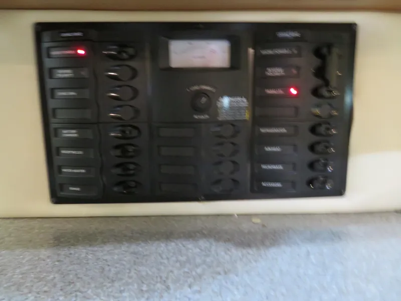 Slide: The Image of Control panel of a 2005 Maxum 3300 SE boat with switches and indicators. - 13