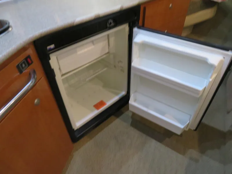 Slide: The Image of Open refrigerator inside 2005 Maxum 3300 SE boat cabin, showcasing interior storage space. - 4