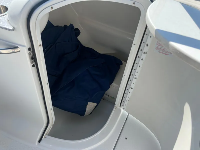 Slide: The Image of Storage compartment of a 2006 Formula 240 Bowrider boat with blue cover inside. - 17