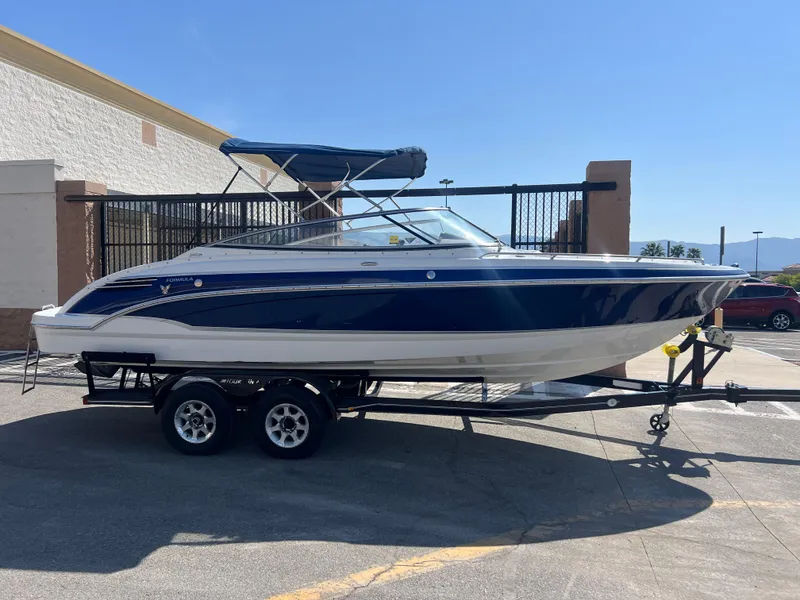 Slide: The Image of 2006 Formula 240 Bowrider boat on a trailer in a parking lot. - 2