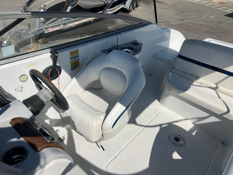 Slide: The Image of 2006 Formula 240 Bowrider boat interior with white seating and steering wheel. - 23