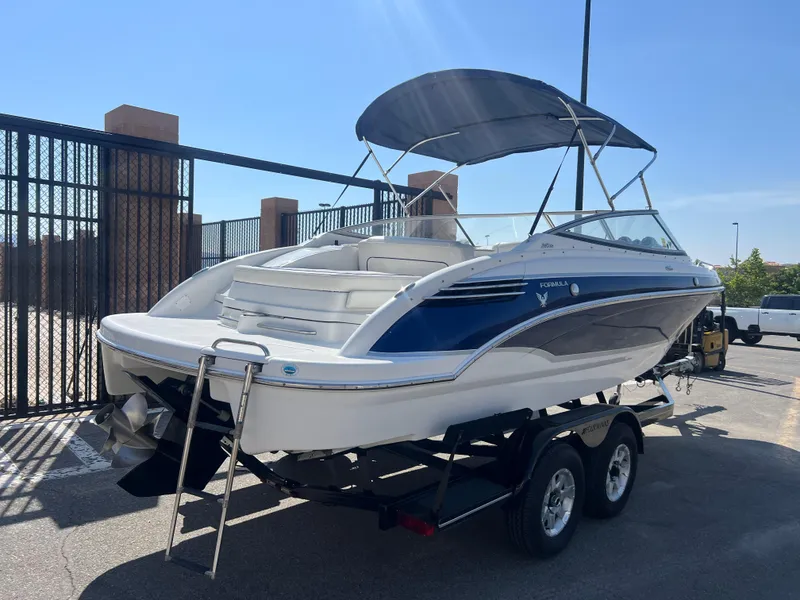 Slide: The Image of 2006 Formula 240 Bowrider boat on a trailer with a blue canopy. - 3