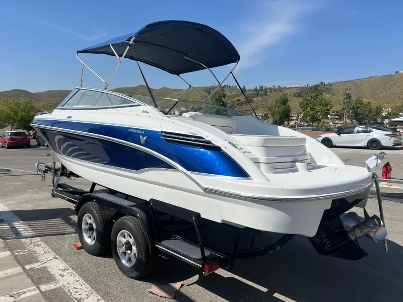 Slide: The Image of 2006 Formula 240 Bowrider boat on a trailer with blue and white exterior. - 5