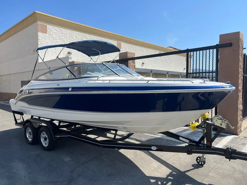 Slide: The Image of 2006 Formula 240 Bowrider boat on a trailer, blue and white exterior. - 8