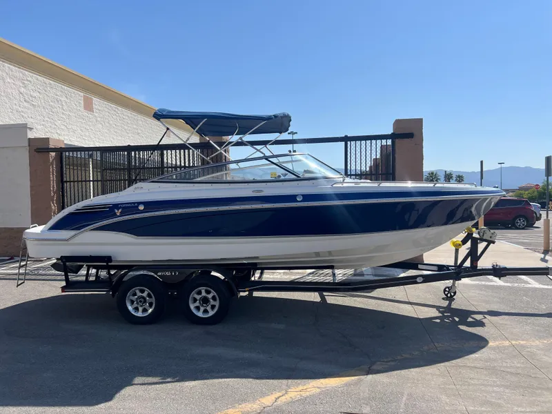 Slide: The Image of 2006 Formula 240 Bowrider boat on a trailer in a parking lot. - 9