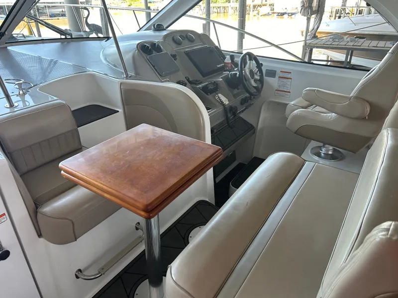 Slide: The Image of 2009 Cruisers 390 Sportcoupe interior with helm, seating, and wooden table. - 9