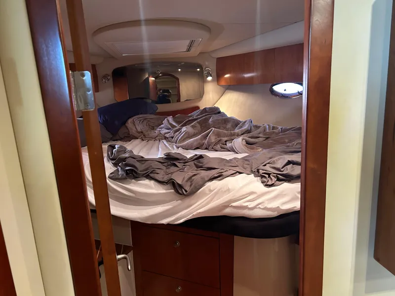 Slide: The Image of 2009 Cruisers 390 Sportcoupe cabin interior with unmade bed and wooden furnishings. - 18