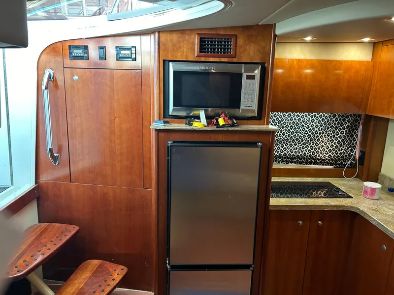 Slide: The Image of 2009 Cruisers 390 Sportcoupe interior with kitchen appliances and wooden cabinetry. - 19