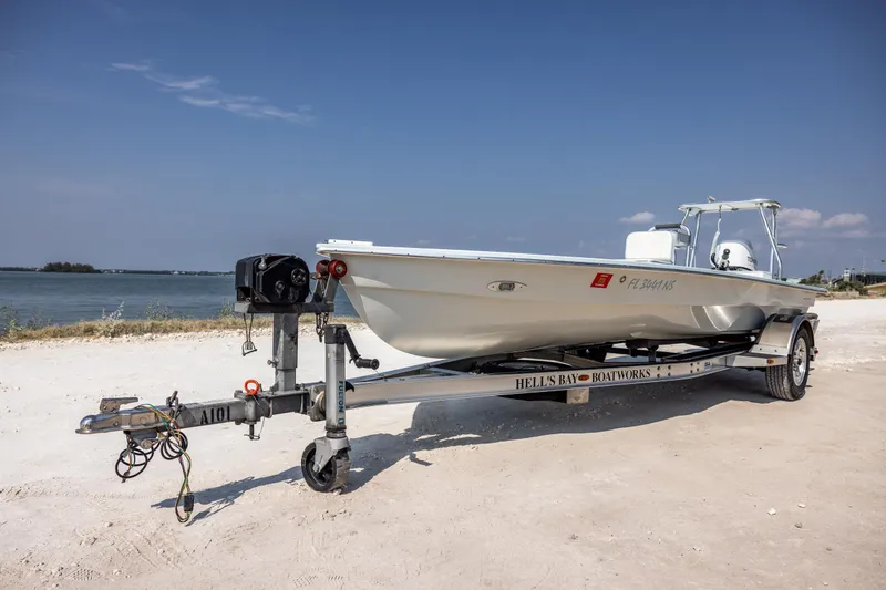 Slide: The Image of 2008 Hell's Bay Waterman 16 boat on a trailer by the shore. - 2