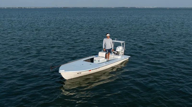 Slide: The Image of 2008 Hell's Bay Waterman 16 boat on open water with a person standing. - 40