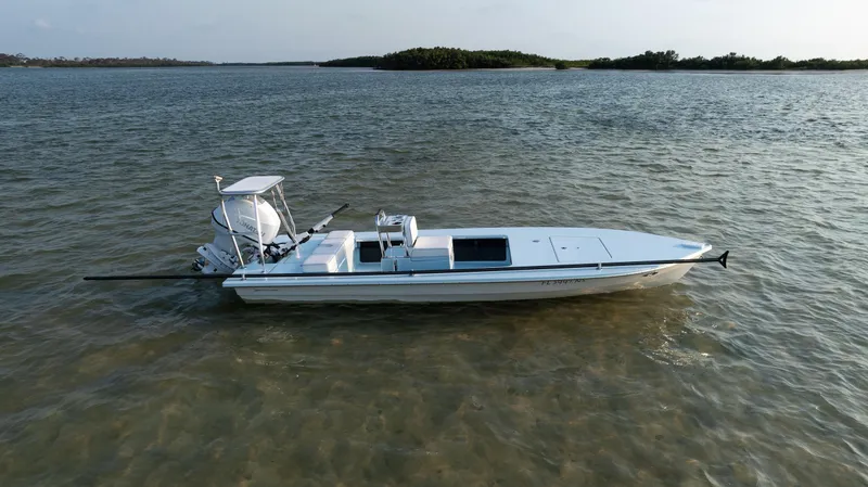 Slide: The Image of 2008 Hell's Bay Waterman 16 skiff on calm waters near a small island. - 44