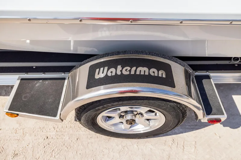 Slide: The Image of 2008 Hell's Bay Waterman 16 boat trailer with branded fender on sandy ground. - 9