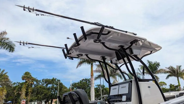 Slide: The Image of 2023 Sea Born SX239 Offshore boat with fishing rods and palm trees in the background. - 14