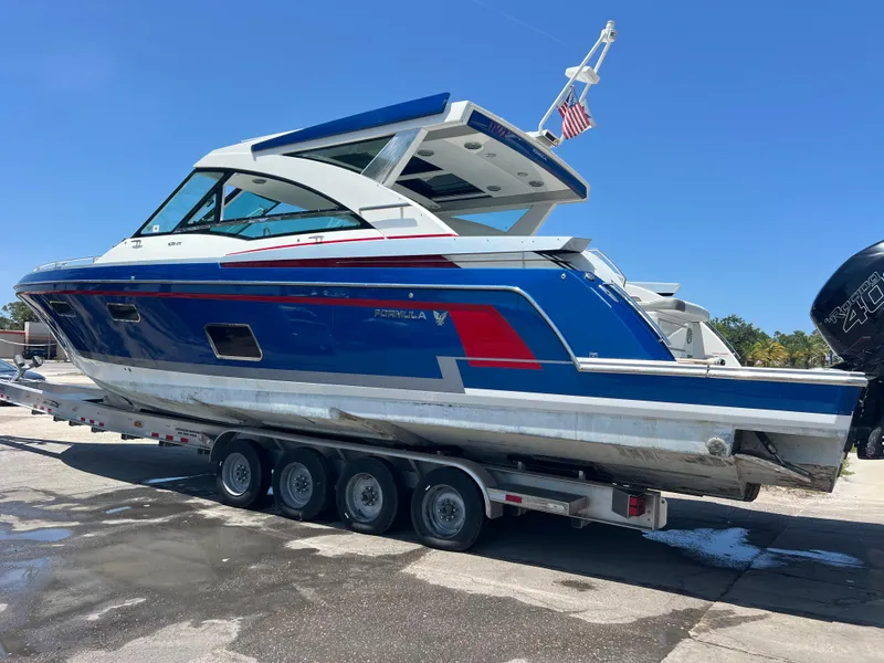 Slide: The Image of 2017 Formula 430 Super Sport Crossover boat on trailer, blue and white design. - 5