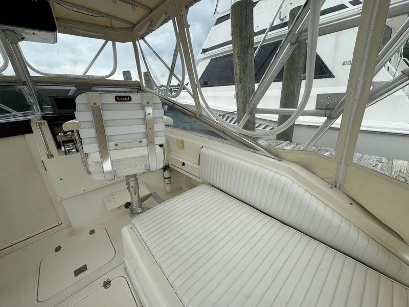 Slide: The Image of 1992 Blackfin 29 Express boat interior with white seating and helm chair. - 10