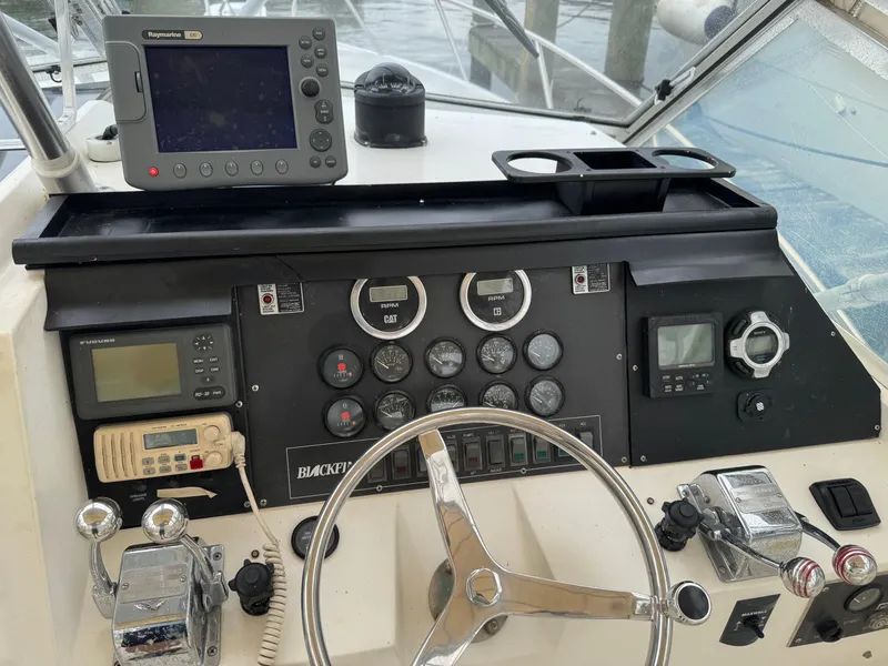 Slide: The Image of 1992 Blackfin 29 Express boat dashboard with navigation equipment and steering wheel. - 12