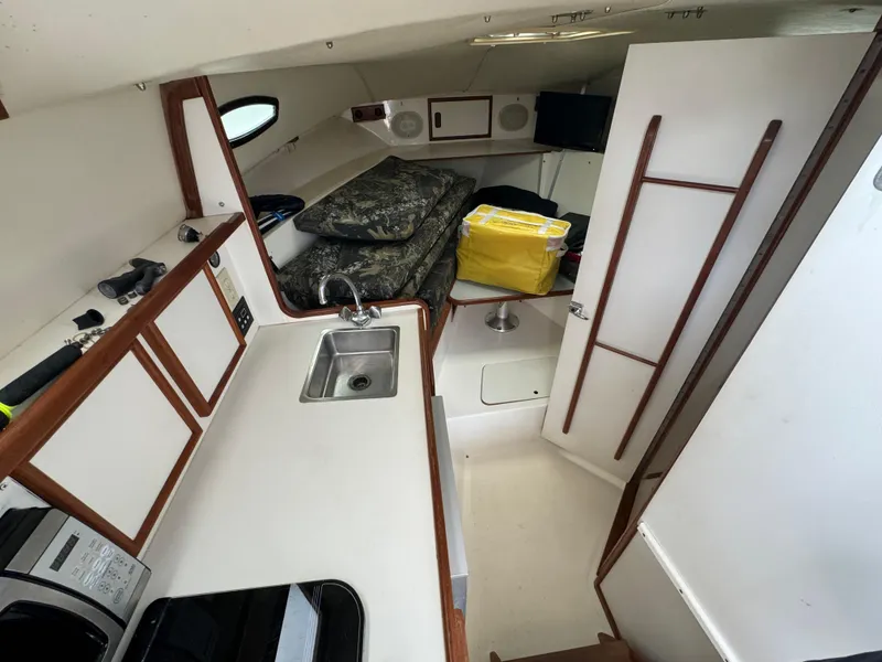 Slide: The Image of 1992 Blackfin 29 Express cabin interior with sink, storage, and sleeping area. - 16