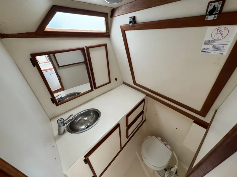 Slide: The Image of 1992 Blackfin 29 Express boat bathroom with sink, mirror, and toilet. - 19
