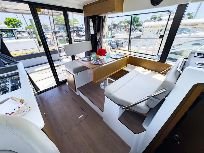 Slide: The Image of Interior of 2021 Jeanneau NC 1095 FLY boat with dining area and large windows. - 10