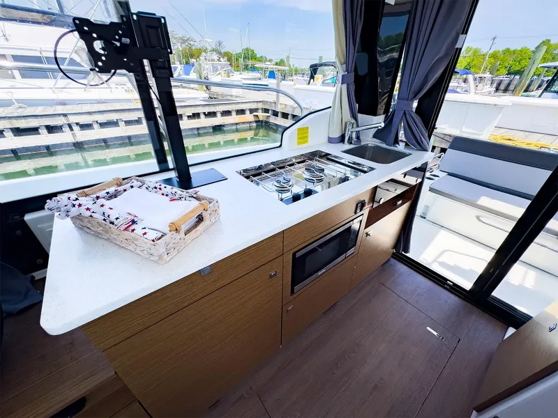 Slide: The Image of 2021 Jeanneau NC 1095 FLY boat kitchen with modern appliances and marina view. - 14