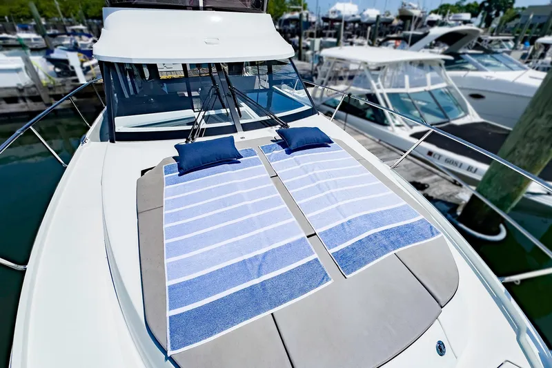 Slide: The Image of 2021 Jeanneau NC 1095 FLY with sunbathing area and striped towels on deck. - 25