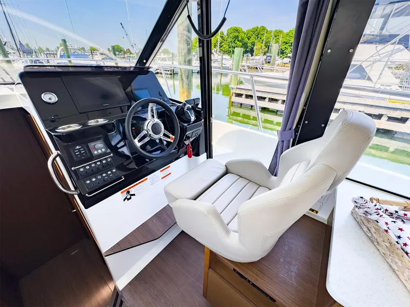 Slide: The Image of 2021 Jeanneau NC 1095 FLY helm station with modern controls and comfortable captain's chair. - 3