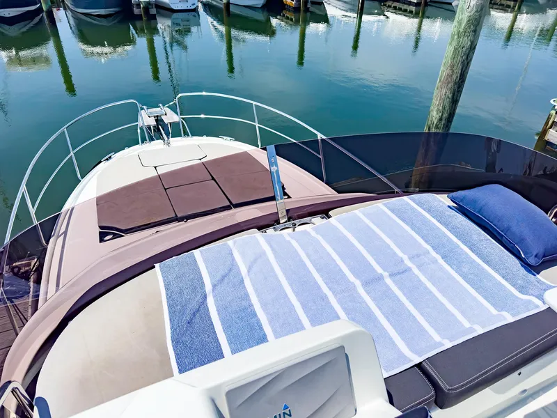 Slide: The Image of 2021 Jeanneau NC 1095 FLY yacht with sunbathing area and striped towel at marina. - 30