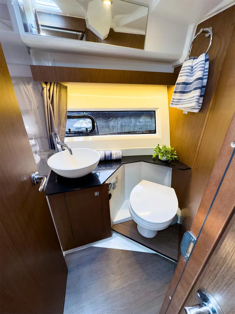 Slide: The Image of Modern bathroom in 2021 Jeanneau NC 1095 FLY boat with sink, toilet, and window. - 38