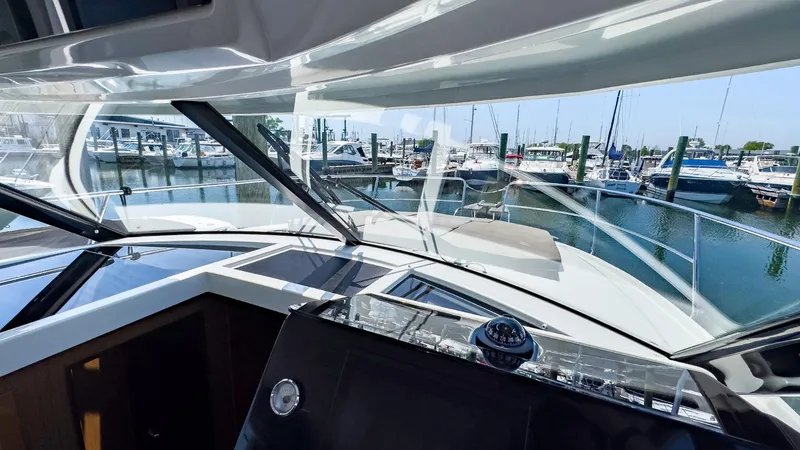 Slide: The Image of Jeanneau NC 1095 FLY 2021 boat interior with marina view through windshield. - 7
