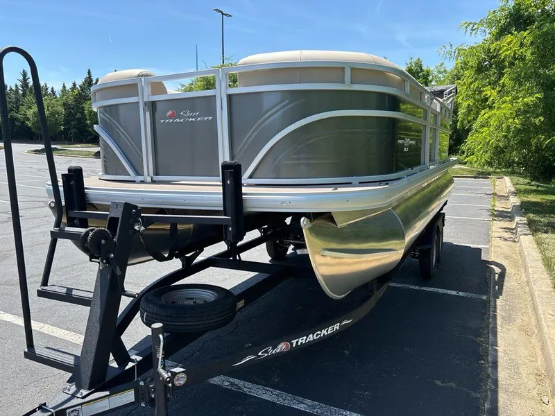 Slide: The Image of 2024 Sun Tracker Party Barge 20 DLX pontoon boat on trailer in parking lot. - 3