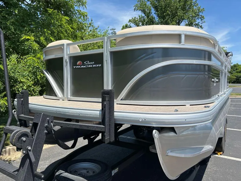 Slide: The Image of 2024 Sun Tracker Party Barge 20 DLX pontoon boat on trailer, parked outdoors. - 7