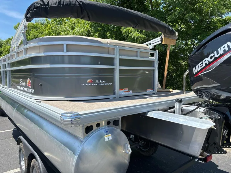 Slide: The Image of 2024 Sun Tracker Party Barge 20 DLX pontoon boat with Mercury engine, parked outdoors. - 8