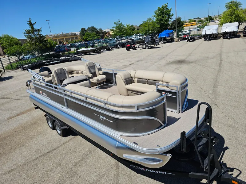Slide: The Image of 2024 Sun Tracker Party Barge 24 DLX pontoon boat in a parking lot. - 2