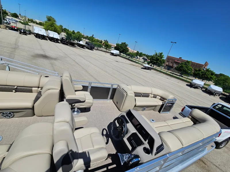 Slide: The Image of 2024 Sun Tracker Party Barge 24 DLX pontoon boat with beige seating in a parking lot. - 3