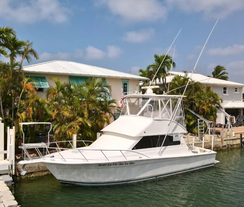 Slide: The Image of 2001 Egg Harbor 37 Convertible yacht docked near waterfront homes. - 0