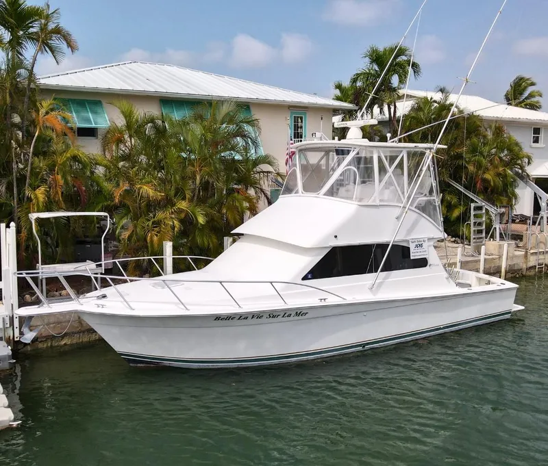 Slide: The Image of 2001 Egg Harbor 37 Convertible yacht docked near tropical homes. - 1