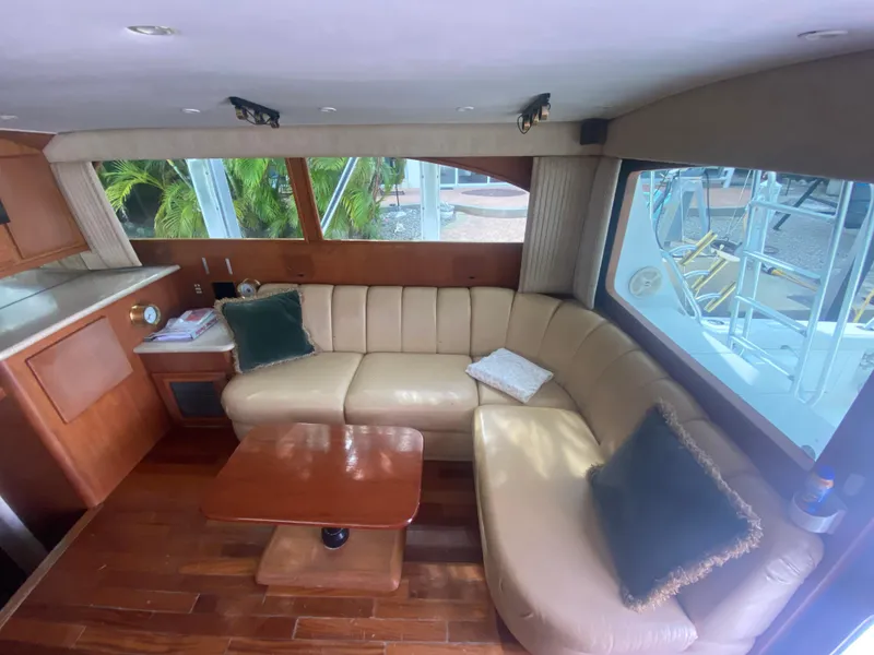 Slide: The Image of Interior of 2001 Egg Harbor 37 Convertible yacht with leather seating and wooden table. - 13