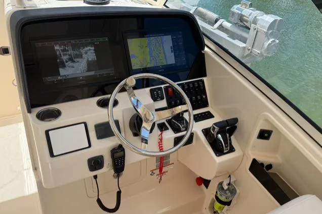 Slide: The Image of Cockpit of 2018 Grady-White Freedom 325 boat with navigation screens and controls. - 18