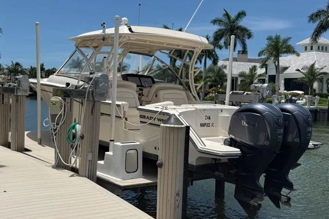 Slide: The Image of 2018 Grady-White Freedom 325 boat docked, featuring dual Yamaha engines, in a sunny marina setting. - 19