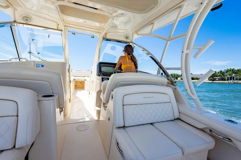 Slide: The Image of 2018 Grady-White Freedom 335 interior with woman at helm, cruising on a sunny day. - 5