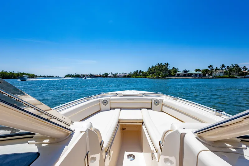 Slide: The Image of 2018 Grady-White Freedom 335 boat on a sunny day, cruising near a tropical shoreline. - 7